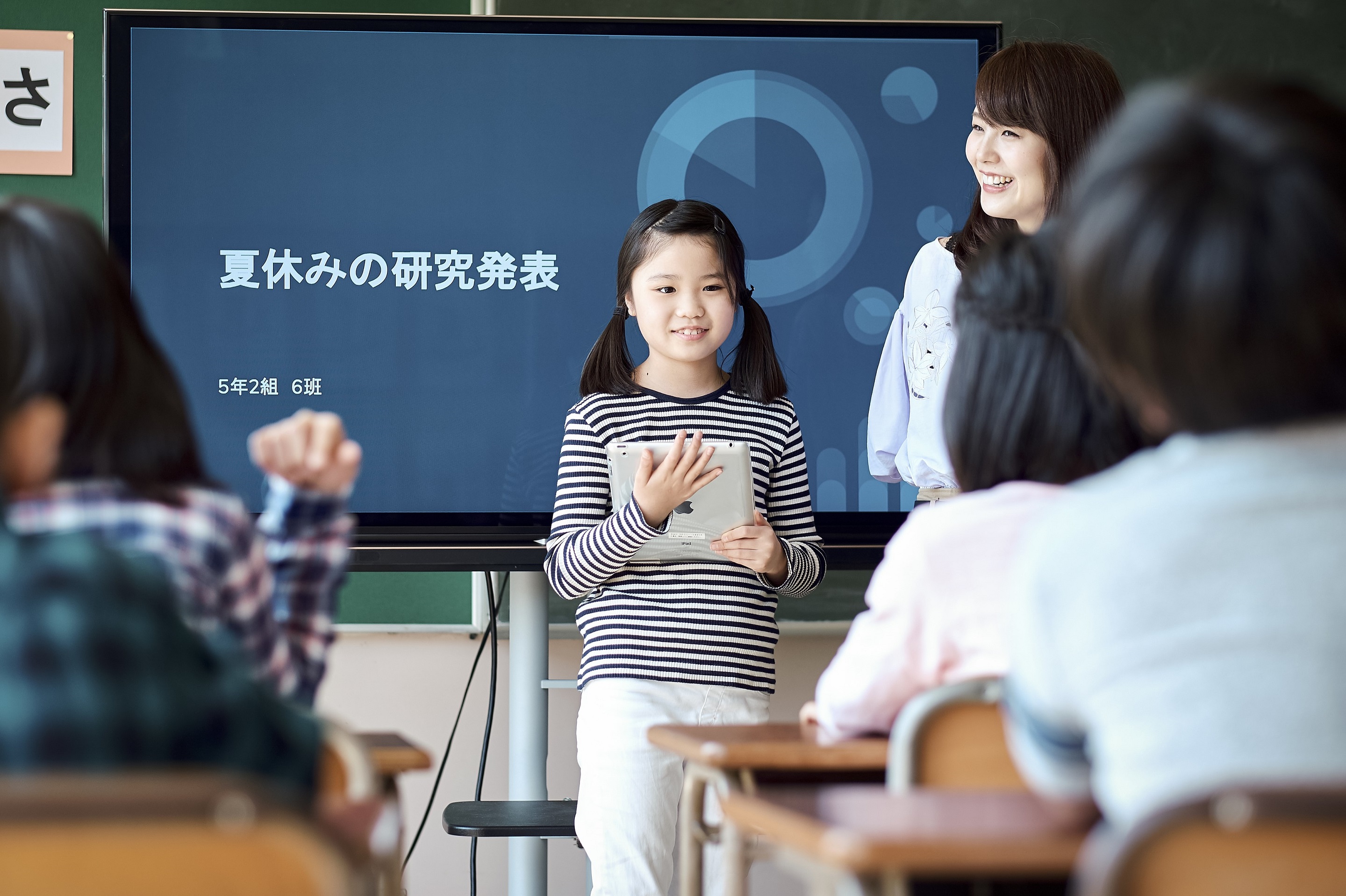 教室で意見を発表する小学生